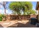 Fenced backyard featuring gravel landscaping, stepping stones, and mature trees providing shade and privacy at 1835 S Rockwell St, Gilbert, AZ 85295