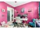 Bright home office with pink walls, modern desk, computer setup, and colorful accent chair at 1835 S Rockwell St, Gilbert, AZ 85295