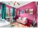 Vibrant home office with pink walls, desk, sofa, colorful rug and natural light from windows at 1835 S Rockwell St, Gilbert, AZ 85295