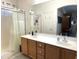 Bathroom featuring double sink vanity with shower and white curtain, and mirrored wall at 18427 E Verde Ct, Gold Canyon, AZ 85118