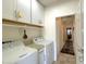 Bright laundry room with white cabinetry, shelving, and modern washer and dryer at 18427 E Verde Ct, Gold Canyon, AZ 85118