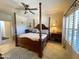 Main bedroom featuring four-poster bed, bedside tables, ceiling fan and tile floors at 18427 E Verde Ct, Gold Canyon, AZ 85118