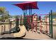 Large playground area with play structure, slides, and overhead shade structure with a clear blue sky at 18427 E Verde Ct, Gold Canyon, AZ 85118