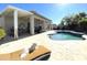 Relaxing poolside scene featuring a cozy lounge chair and a sparkling pool in a backyard setting at 18427 E Verde Ct, Gold Canyon, AZ 85118