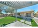 A covered patio provides a cool outdoor retreat, overlooking a grassy yard and a house with solar panels at 19808 N 3Rd Ave, Phoenix, AZ 85027