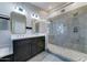 Modern bathroom with dual sinks, dark cabinets, quartz counters, and a glass-enclosed shower at 19808 N 3Rd Ave, Phoenix, AZ 85027