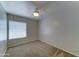 Cozy bedroom featuring neutral carpet, a ceiling fan, and a bright window with blinds at 19808 N 3Rd Ave, Phoenix, AZ 85027