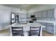 Modern kitchen with gray cabinets, stainless steel appliances, and a quartz island at 19808 N 3Rd Ave, Phoenix, AZ 85027