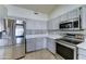 Stylish kitchen with stainless appliances, gray cabinets, and light countertops at 19808 N 3Rd Ave, Phoenix, AZ 85027