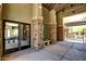 Elegant clubhouse entrance with stone pillars, cozy bench, and modern glass doors at 20750 N 87Th St # 1065, Scottsdale, AZ 85255