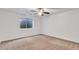 Comfortable basement with a window, neutral carpeting, and a modern ceiling fan at 21759 E Estrella Rd, Queen Creek, AZ 85142
