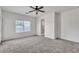 Bright bedroom with a ceiling fan, plush carpet, and large window at 21759 E Estrella Rd, Queen Creek, AZ 85142