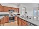 Well-equipped kitchen boasts stainless appliances, an island, and wood cabinets at 21759 E Estrella Rd, Queen Creek, AZ 85142