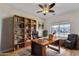 Cozy home office with custom bookcase, wooden desk and comfortable seating at 21759 E Estrella Rd, Queen Creek, AZ 85142