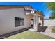Home exterior featuring a back patio with artificial turf, a stucco wall, a satellite dish and mature landscaping at 22225 N 29Th Dr, Phoenix, AZ 85027