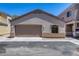 A tan stucco home featuring an attached garage with a brown garage door, and beige trim at 22225 N 29Th Dr, Phoenix, AZ 85027