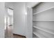 Hallway features neutral colored wall paint, tile flooring, and white shelving at 22225 N 29Th Dr, Phoenix, AZ 85027