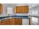 Well-lit kitchen area with stainless steel sink and white dishwasher, open to a large living area at 22225 N 29Th Dr, Phoenix, AZ 85027