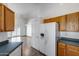 Kitchen featuring wood cabinets, a white refrigerator with an ice maker, and tile flooring at 22225 N 29Th Dr, Phoenix, AZ 85027