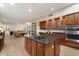 Spacious kitchen with dark granite countertops, wood cabinets, island cooktop and open to the living room at 22233 N 54Th Way, Phoenix, AZ 85054