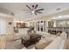 Open-concept living room featuring bright white furniture, a dark wood coffee table, and direct access to the kitchen and bar at 22233 N 54Th Way, Phoenix, AZ 85054