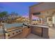 Outdoor kitchen features a built-in grill, sink, and refrigerator, perfect for entertaining by the pool at 22233 N 54Th Way, Phoenix, AZ 85054