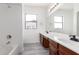 Bright bathroom featuring a double sink vanity, a large mirror, and a shower/tub combo at 2302 S Canfield --, Mesa, AZ 85209