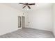 Bright bedroom with white walls and a modern ceiling fan, paired with stylish gray wood-look floors at 2302 S Canfield --, Mesa, AZ 85209
