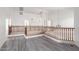 A loft featuring wood railing, neutral paint, and gray wood-look floors, creating a modern and inviting space at 2302 S Canfield --, Mesa, AZ 85209