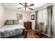 This bedroom has a ceiling fan, wood-look flooring, a rocking chair and nature views at 2419 E Billings St, Mesa, AZ 85213