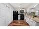 Kitchen featuring white cabinets, wooden floors, black appliances, and center island at 2419 E Billings St, Mesa, AZ 85213