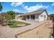 Inviting backyard featuring well-maintained turf, mature trees, a covered patio, and rock landscaping for low maintenance at 2615 W Silver Streak Way, San Tan Valley, AZ 85144