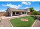 Backyard featuring a covered patio and well-manicured artificial turf, and mature trees providing plenty of shade at 2615 W Silver Streak Way, San Tan Valley, AZ 85144