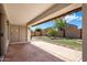 Relaxing covered patio with a retractable awning overlooking a meticulously landscaped backyard with artificial turf and stone accents at 2615 W Silver Streak Way, San Tan Valley, AZ 85144