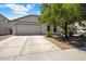 Inviting home featuring a spacious driveway, two-car garage, and mature landscaping at 2615 W Silver Streak Way, San Tan Valley, AZ 85144