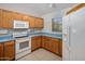Well-maintained kitchen with oak cabinetry, white appliances, and a functional layout at 2615 W Silver Streak Way, San Tan Valley, AZ 85144
