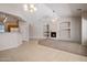Spacious living area seamlessly connecting to the kitchen, featuring a fireplace and high ceilings at 2615 W Silver Streak Way, San Tan Valley, AZ 85144