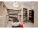 An organized walk-in closet with custom shelving, seating and a washer dryer at 3301 E Elm St, Phoenix, AZ 85018