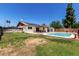 Large backyard featuring an in-ground pool, grass area, and covered patio at 3415 E Anderson Dr, Phoenix, AZ 85032