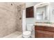 Bathroom featuring a shower, tiled walls, vanity, toilet and mirrored cabinet for a comfortable, functional space at 3415 E Anderson Dr, Phoenix, AZ 85032