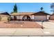 Charming single-story home featuring a decorative front yard with an arched entry and a two-car garage at 3415 E Anderson Dr, Phoenix, AZ 85032