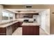 Well-lit kitchen boasting stainless appliances, granite countertops, an island, and wood cabinets for a modern and functional space at 3415 E Anderson Dr, Phoenix, AZ 85032