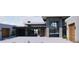 Stunning front exterior with stone accents, a glass entryway, and wood garage doors offers sleek, modern curb appeal at 3648 N Sky Point Cir, Mesa, AZ 85207
