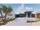 View of a contemporary home with a flat roof, stone and glass entry, and a spacious front driveway and desert landscaping at 3648 N Sky Point Cir, Mesa, AZ 85207