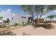 Front exterior view shows desert landscaping and a contemporary home with a flat roof, wood garage doors, and stone accents at 3648 N Sky Point Cir, Mesa, AZ 85207