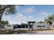 Striking modern home with a flat roof, stone and glass details, and wood garage doors blending with the desert landscape at 3648 N Sky Point Cir, Mesa, AZ 85207