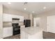 Well-lit kitchen featuring white cabinets and black appliances at 3713 S 54Th Ln, Phoenix, AZ 85043