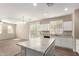 Bright kitchen with island, granite countertops and modern white cabinets at 3713 S 54Th Ln, Phoenix, AZ 85043