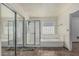 Bright bathroom featuring a glass-enclosed shower and a soaking tub at 4207 W Soft Wind Dr, Glendale, AZ 85310