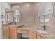 Bathroom vanity with dual sinks, granite countertop and warm wood cabinetry at 4207 W Soft Wind Dr, Glendale, AZ 85310